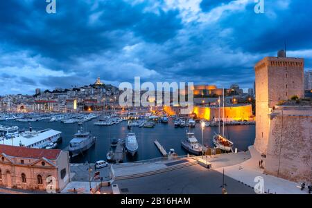 Night Old Port con Forts Saint-Jean e Saint-Nicolas, la Basilica di Notre Dame de la Garde sullo sfondo, sulla collina, Marsiglia, Francia Foto Stock