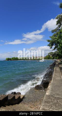 Passeggiata vicino al lago Leman, bellissimo castello Château d'Ouchy sullo sfondo e bellissimo lago blu Leman e cielo Foto Stock