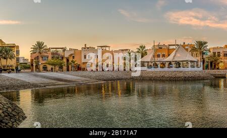 Il lungomare del porto dal mare al tramonto con cielo arancione al New Marina, el Gouna, Egitto, 17 gennaio 2020 Foto Stock