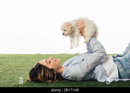 Vista laterale della donna sorridente che tiene il cucciolo Havanese isolato su bianco Foto Stock