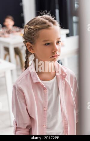 fuoco selettivo di schoolkid frustrato in piedi in classe, concetto di bullismo Foto Stock