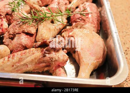 Closeup di tagli crudi browned parti di anatra in un tegame di roating Foto Stock