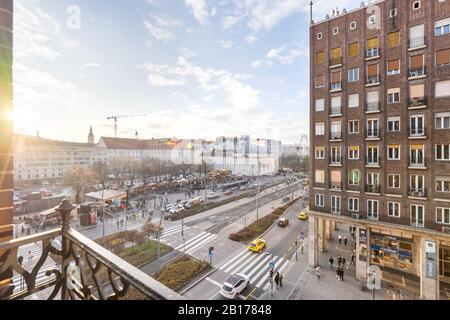 Budapest, Ungheria - 14 dicembre 2019: La finestra di Piazza Madach si affaccia sulla strada verso Deák tér in una giornata di sole con il mercato della fiera di Natale. Foto Stock