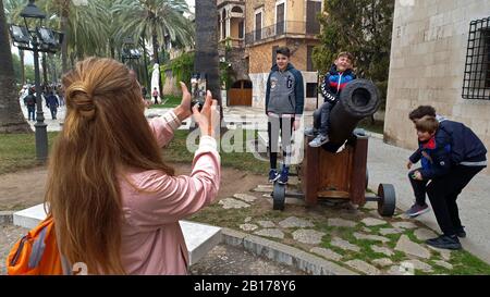 Madre scattare foto dei suoi figli a un cannone nella città vecchia di Alcúdia, Spagna, Isole Baleari, Maiorca, Alcudia Foto Stock