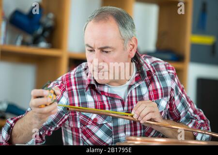 ritratto di un lavoratore con cooper pipe Foto Stock