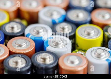 Primo piano delle estremità positive delle batterie colorate scaricate di diverse dimensioni e formati, . Concetto di rifiuti pericolosi Foto Stock