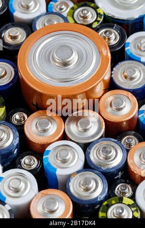 Primo piano delle estremità positive delle batterie colorate scaricate di diverse dimensioni e formati, . Concetto di rifiuti pericolosi Foto Stock
