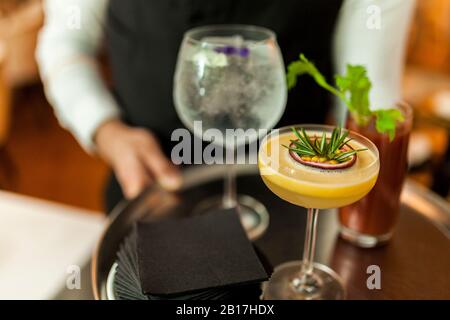 Il cameriere serve cocktail sul vassoio d'argento Foto Stock