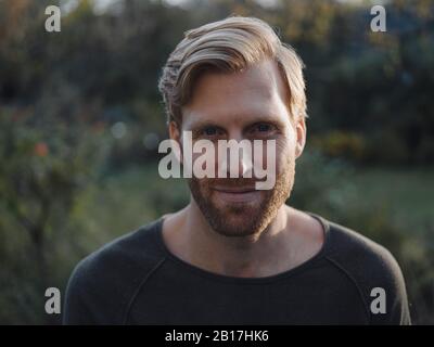 Ritratto di uomo sorridente in giardino Foto Stock