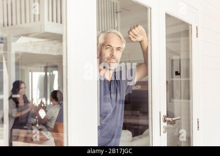 Ritratto di uomo maturo che guarda fuori dalla finestra Foto Stock