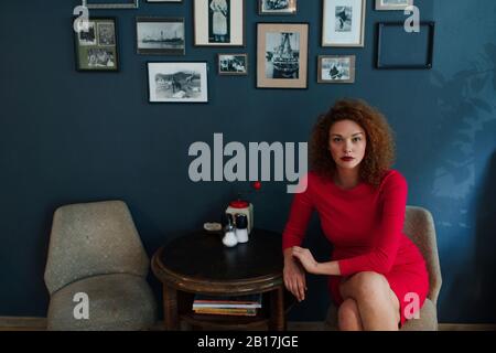 Ritratto di donna dai capelli rossi seduta in un bar Foto Stock