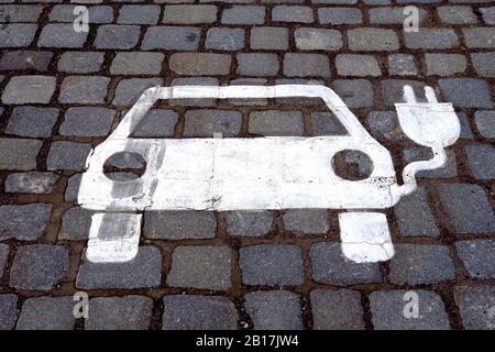 Germania, Baden-Wurttemberg, simbolo della stazione di ricarica per veicoli elettrici su ciottoli Foto Stock