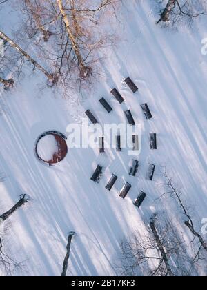 Panchine vuote nel parco innevato, vista sui droni Foto Stock