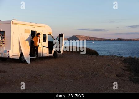 Uomo che esce fuori camper, es Mercadal, Minorca, Spagna Foto Stock