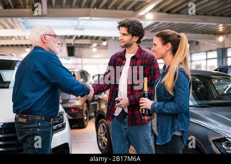 Coppia che acquista un'auto nuova presso il concessionario di automobili Foto Stock