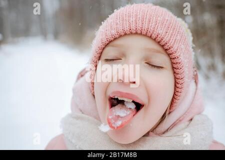 Ritratto di ragazza con gli occhi chiuso degustazione neve Foto Stock