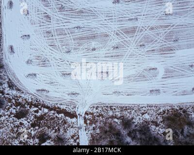 Russia, regione di Mosca, veduta aerea delle piste di pneumatici sul campo coperto di neve Foto Stock