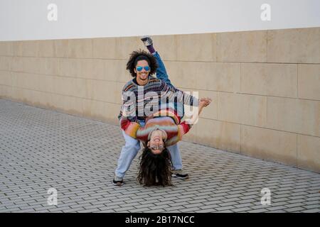 Un paio di ballerini che ballano davanti a un muro Foto Stock