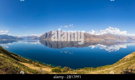 Nuova Zelanda, Queenstown-Lakes District, Wanaka, vista panoramica delle colline che si riflettono nel lago Hawea Foto Stock