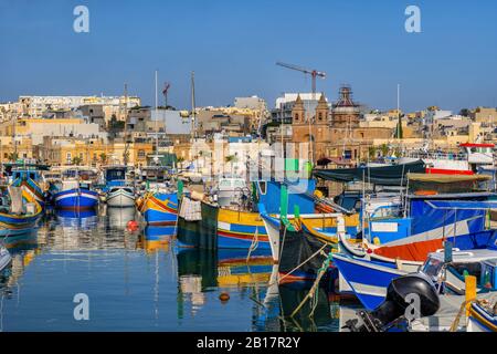 Malta, Marsaxlokk, porto della città di pesca con le tradizionali barche Luzzu Foto Stock