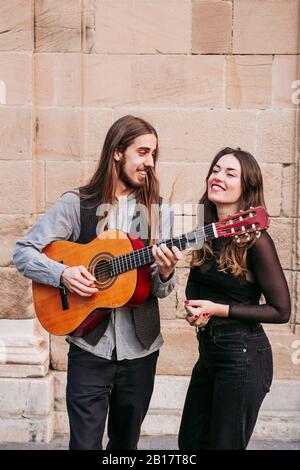 Ritratto di due giovani musicisti sorridenti in città Foto Stock