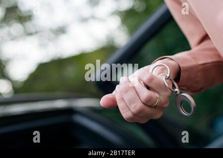 Mano della donna che tiene la chiave dell'automobile, primo piano Foto Stock