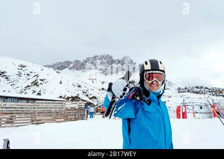 Portait di uomo sorridente con sci in area sciistica Foto Stock