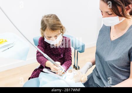 Ragazza al dentista che esamina orsacchiotto Foto Stock