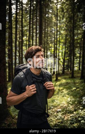 Uomo con zaino in un viaggio escursionistico in foresta, Karwendel, Tirolo, Austria Foto Stock