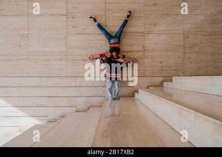 Coppia di ballerini su un muro, donna che si bilancia capovolto sull'uomo Foto Stock