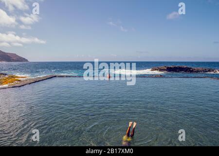 Spagna, la Gomera, Hermigua, uomo che nuota in piscina di acqua di mare Foto Stock