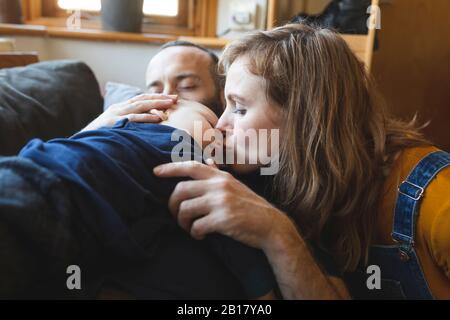 Famiglia affettuosa sul divano con piccolo figlio che dorme Foto Stock