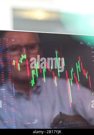 Riflessione di un operatore di borsa che visualizza sullo schermo le prestazioni di un prezzo di azione dell'azienda Foto Stock