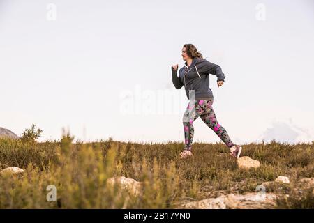 Plus-Size-Model jogging in campagna Foto Stock