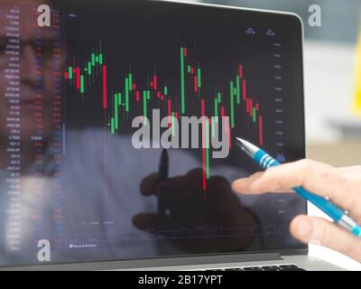 Riflessione di un operatore di borsa che visualizza sullo schermo le prestazioni di un prezzo di azione dell'azienda Foto Stock