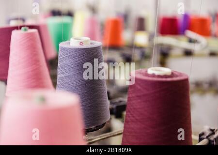 Dettaglio di bobine di cotone multicolore in una fabbrica Foto Stock