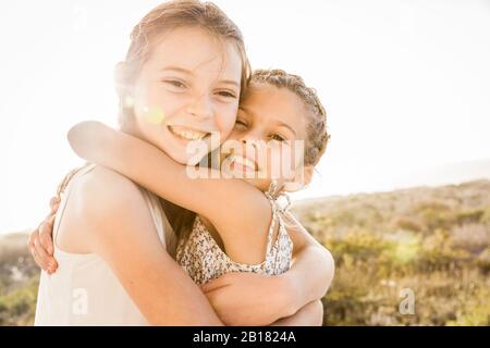 Ritratto di due ragazze carine felice che abbracciano al tramonto Foto Stock