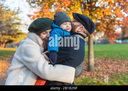 Felice affettuosa coppia con bambino figlio al parco Foto Stock