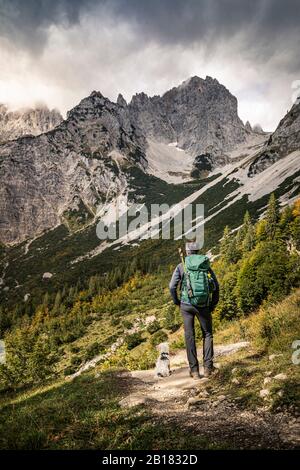 Donna in un viaggio a piedi a Wilder Kaiser godendo della vista, Kaiser montagne, Tirolo, Austria Foto Stock