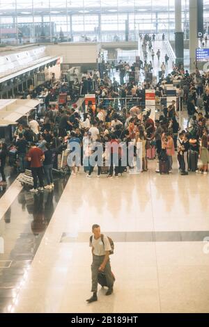 Aeroporto affollato con coda di check-in all'aeroporto di Hong Kong. Foto Stock