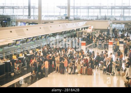 Aeroporto affollato con coda di check-in all'aeroporto di Hong Kong. Foto Stock