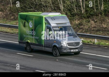 Sfocata auto in movimento Ocado Consegna del cibo drogheria che viaggiano a velocità sulla M61 Autostrada lenta velocità dello shutter di movimento del veicolo Foto Stock