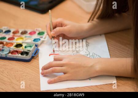 Ragazza dipinge un libro da colorare per gli adulti con pastelli Foto Stock