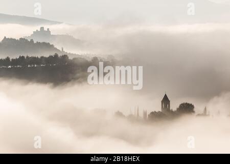 Surreale in vista di una piccola città in Umbria (Italia) quasi completamente nascosto dalla nebbia Foto Stock