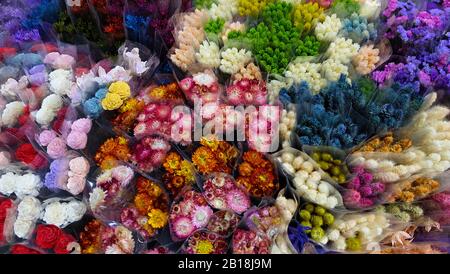 Una varietà di fiori colorati avvolti in involucri trasparenti. Vista dall'alto. Foto Stock