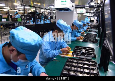 Pechino, Cina. 24th Feb, 2020. Il personale che indossa le maschere lavora presso la fabbrica DI OPPO a Dongguan, nella provincia del Guangdong della Cina meridionale, 13 febbraio 2020. PER ANDARE CON XINHUA TITOLI DI FEB. 24, 2020 Credit: Xinhua/Alamy Live News Foto Stock