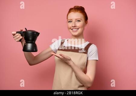 Una barista femminile con un grembiule bianco si pone dietro il bar in un  caffè. Una bella donna imprenditore nel suo bar Foto stock - Alamy