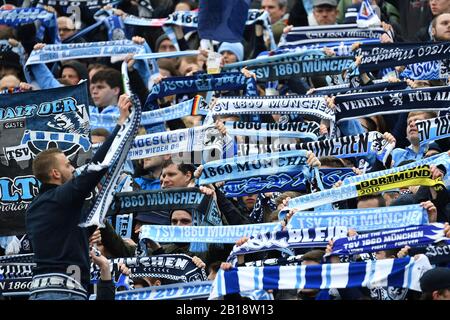 Monaco, Germania. 23rd Feb, 2020. Fan, tifosi di calcio 1860 swing loro sciarpe fan. Campionato di calcio 3rd, 25th matchday, TSV Monaco 1860 - 1.FC Magdeburg 1-1, il 02/23/2020. Stadium on Gruenwalder Strasse a Monaco di Baviera, LE NORMATIVE DFL VIETANO L'USO DI FOTOGRAFIE COME SEQUENZE DI IMMAGINI E/O QUASI-VIDEO. | utilizzo credito mondiale: DPA/Alamy Live News Foto Stock