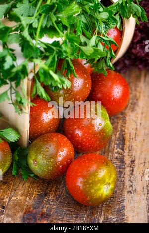 Pomodori, cucinati con erbe per la conservazione del vecchio tavolo in legno. Foto Stock