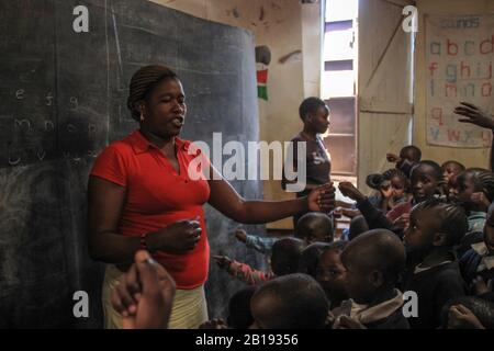 Kibera, Nairobi, Kenya - 13 febbraio 2015: Insegnante di volontariato africano nella scuola più povera di Kibera Foto Stock
